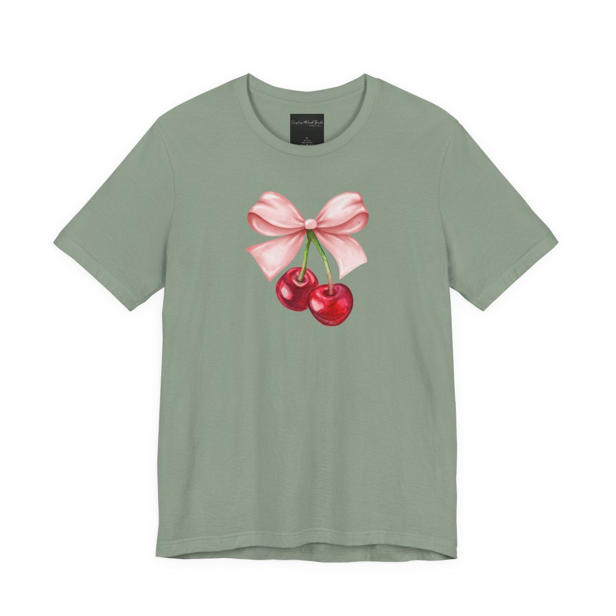 On the front of this custom women's short sleeve shirt is an image of a pair of cherries hanging from a stem with a pink bow on the top of them.