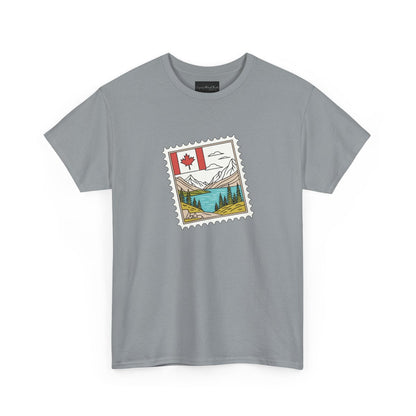On the front of this custom Canadian pride short sleeve shirt is an image of a Canadian postage stamp with the Canadian flag in one corner and an image of mountains, a lake, and trees the make up the rest of the stamp.