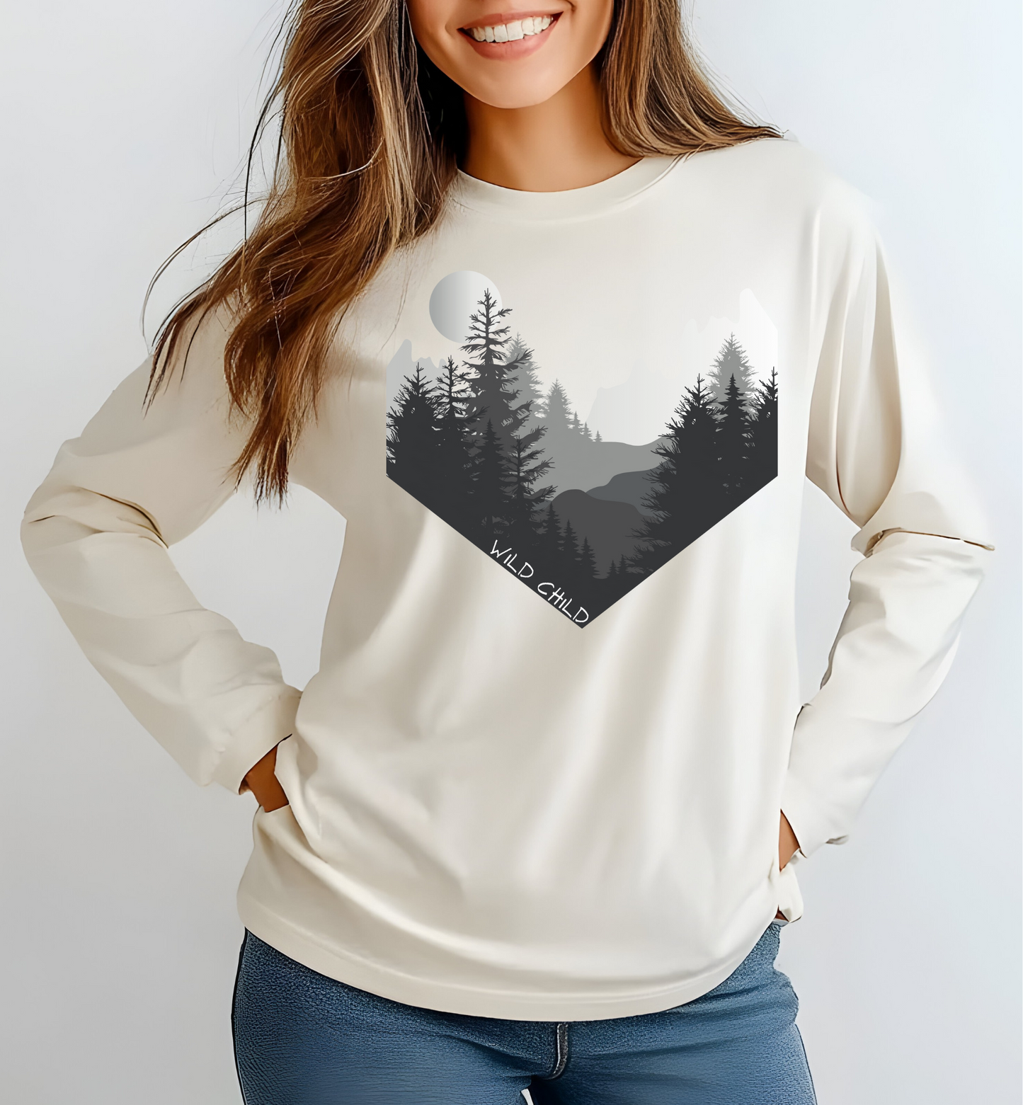 The image on the front of this custom long sleeve shirt is all in black and grey with there being mountains and trees on both sides in the shape on a v making it looking as if you are looking down a valley, the words wild child are in white on the bottom left of the image.