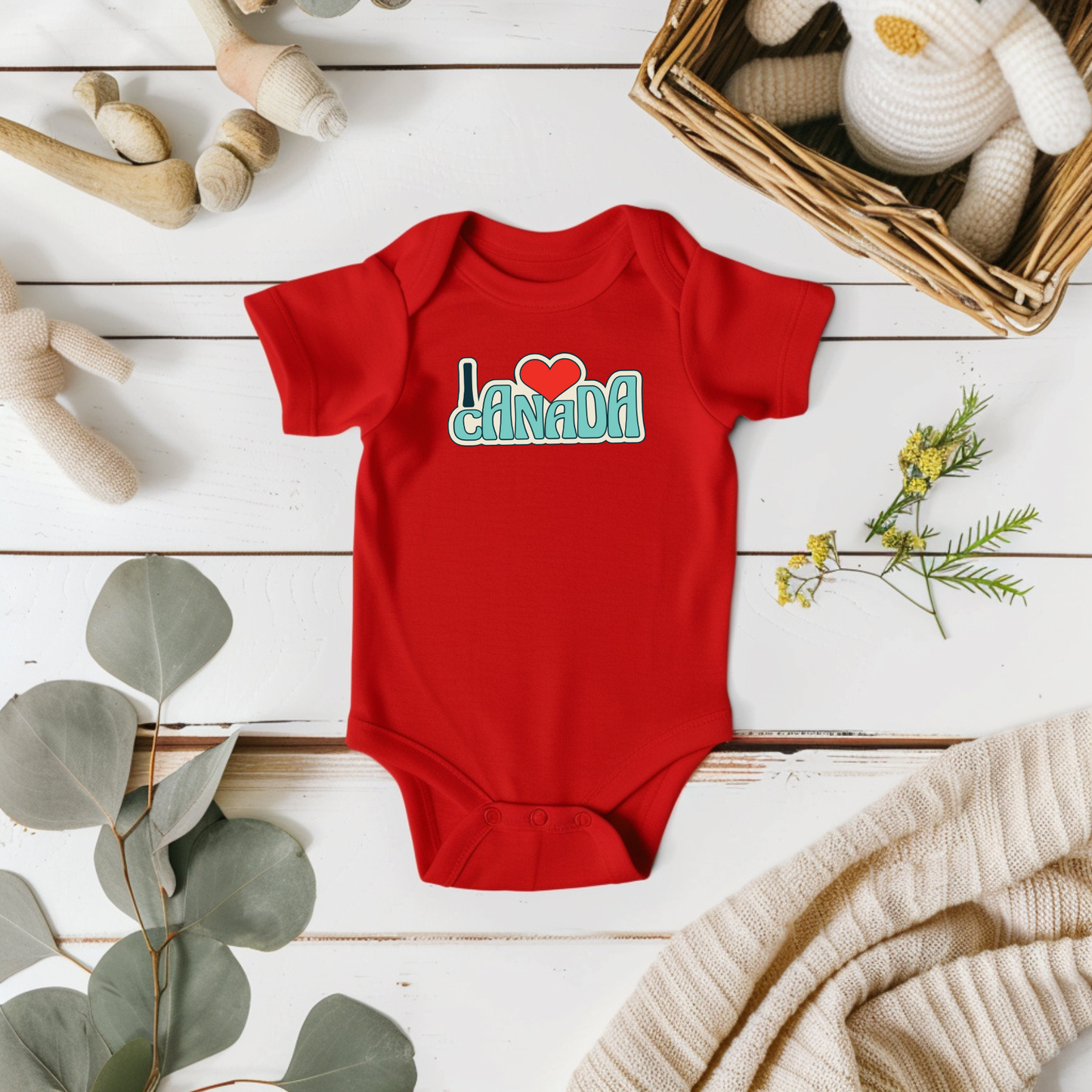 On the front of this custom baby onesie are the words I Love Canada in large bubble letters with the  word love being a heart, the image has a retro look to it.