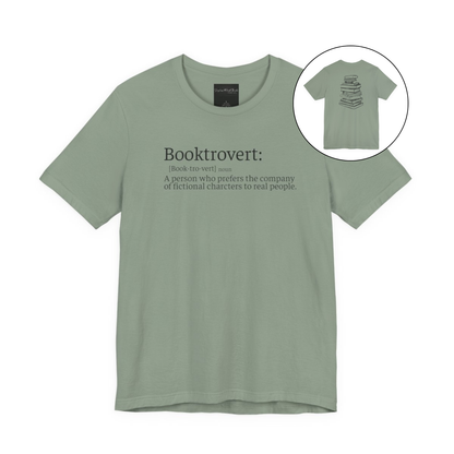 On the front of this custom unisex short sleeve shirt is the word booktrovert with the definition of the word underneath, on the back of the shirt is an image of a large stack of books.