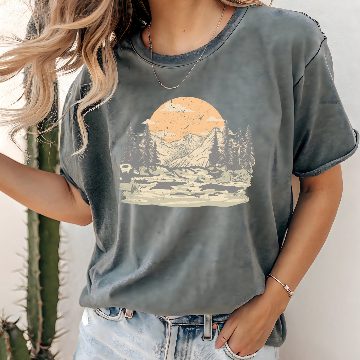 On the front of this custom comfort colors short sleeve t-shirt is a large vintage image of a large valley that opens up to a mountain range with pine trees , there is a large sun in the background with birds flying all around, this t-shirt is completely vintage.