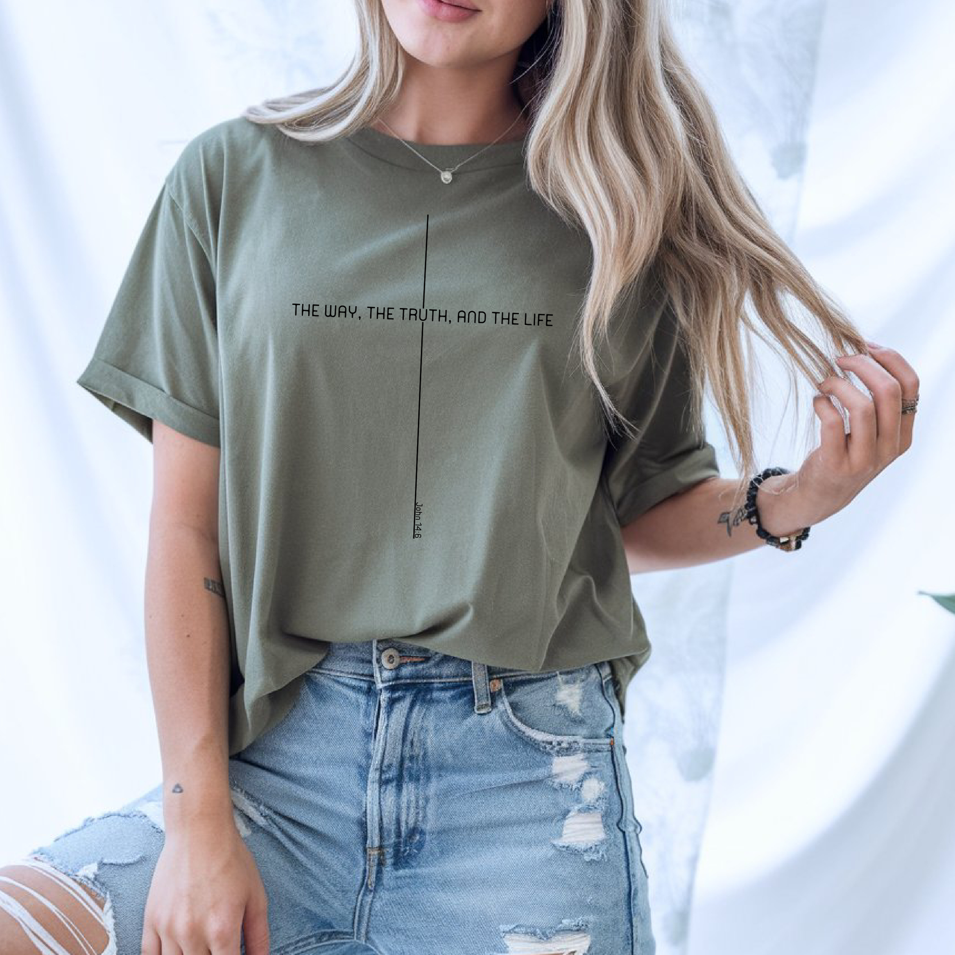 On the front of this custom faith inspired handmade t-shirt is a cross with the bible verse The Way, The Truth, and The Life John 14:6 in a modern font.