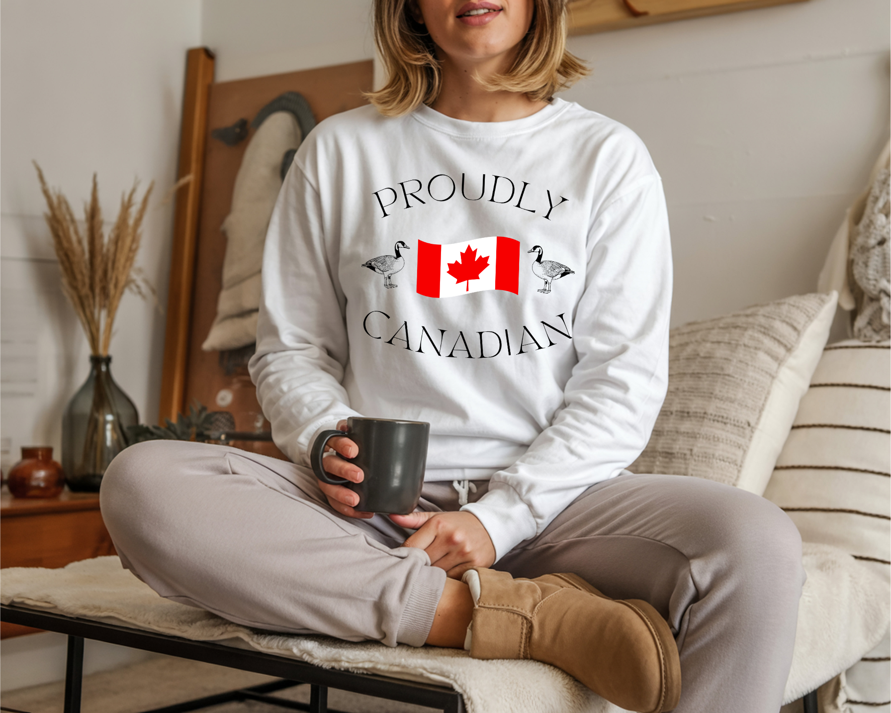 On the front of this Canadian made unisex custom long sleeve t-shirt are the words Proudly Canadian in large font with an image of a Canadian flag in the center, there are two Canadian geese on either side of the flag.