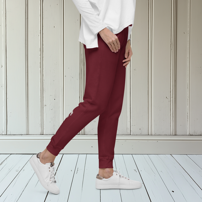 A pair of super soft custom unisex fleece sweatpants with a male lion head on the back calf of the right leg embroidered in silver.