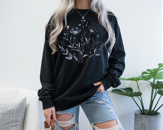 On the front of this custom women's long sleeve t-shirt is a image of a bunch of wildflowers and leaves coming from the bottom of the shirt to the very top, the flowers and leaves are in a light blue color.
