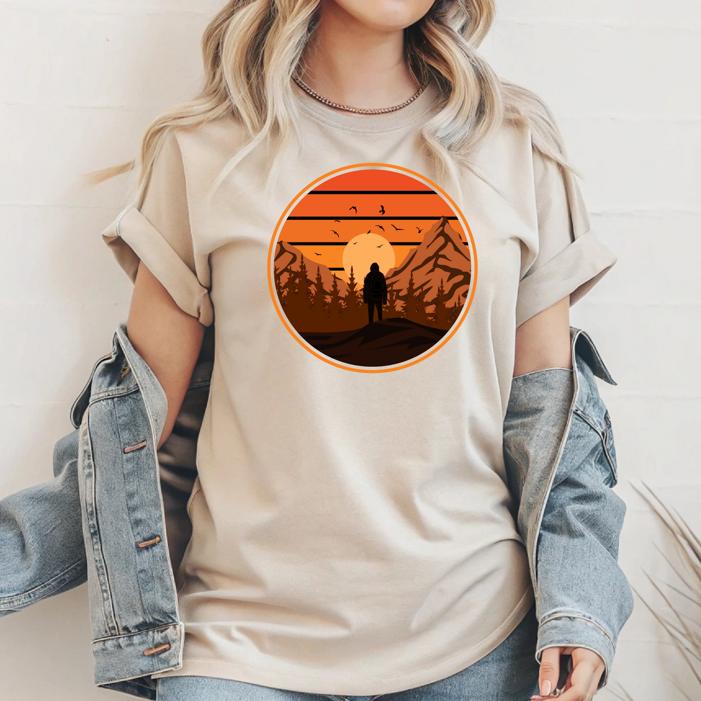 On the front of this custom tee is a large circle on the center of the chest that has an image of bigfoot right in the middle, there is a sun setting with mountain ranges and pine trees in the background.