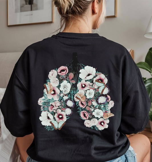 On the back of this women's pullover sweatshirt is an image of a set of lungs, but the lungs are made out of vines with pink and white flowers all over them, there are butterflies sitting in top of the flowers that are light blue in color.