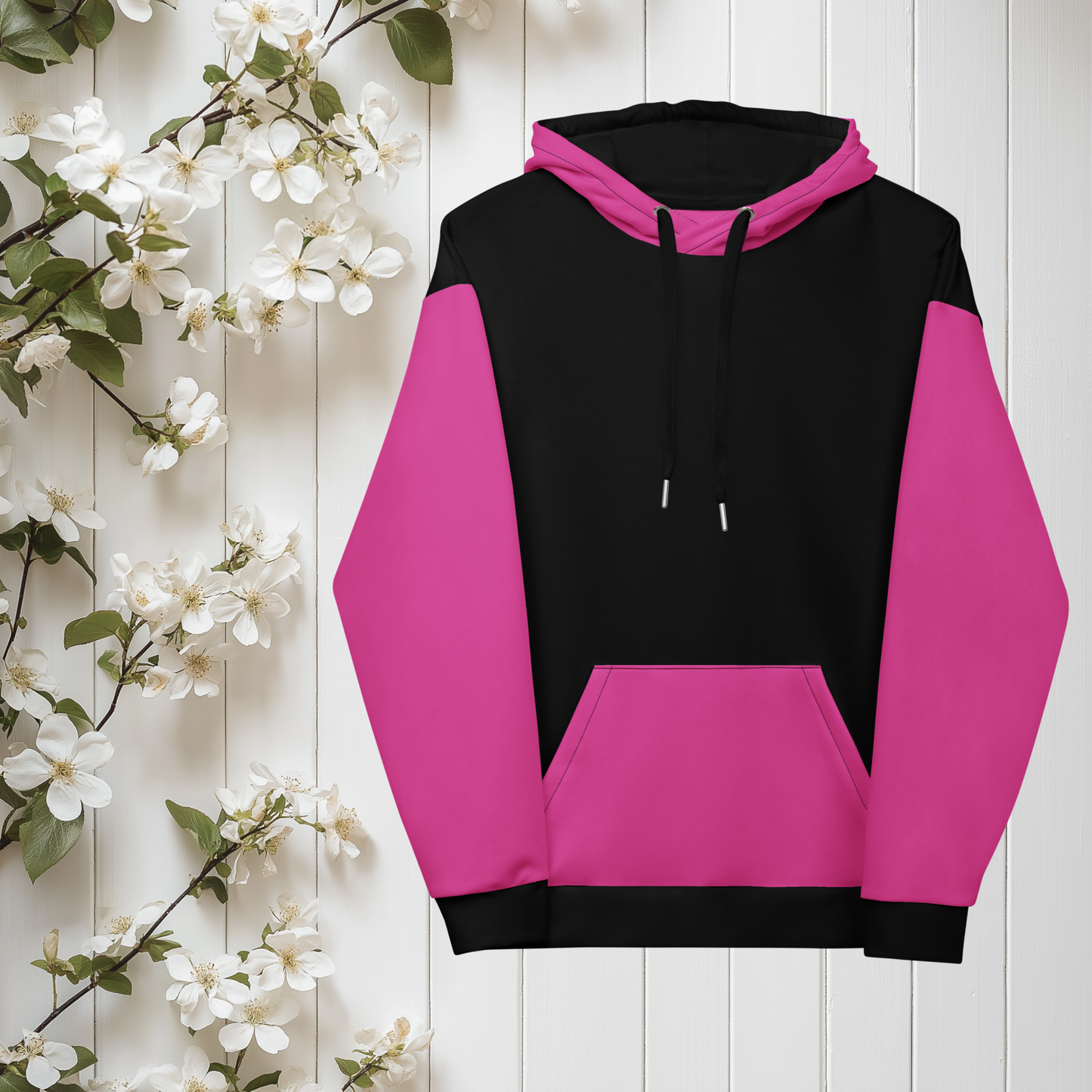 A women's custom oversized handmade hoodie, on the front and the back of the hoodie is the color black, the sleeves, front kangaroo pocket and hood are all a bright pink color, the strings of the sweater are black.