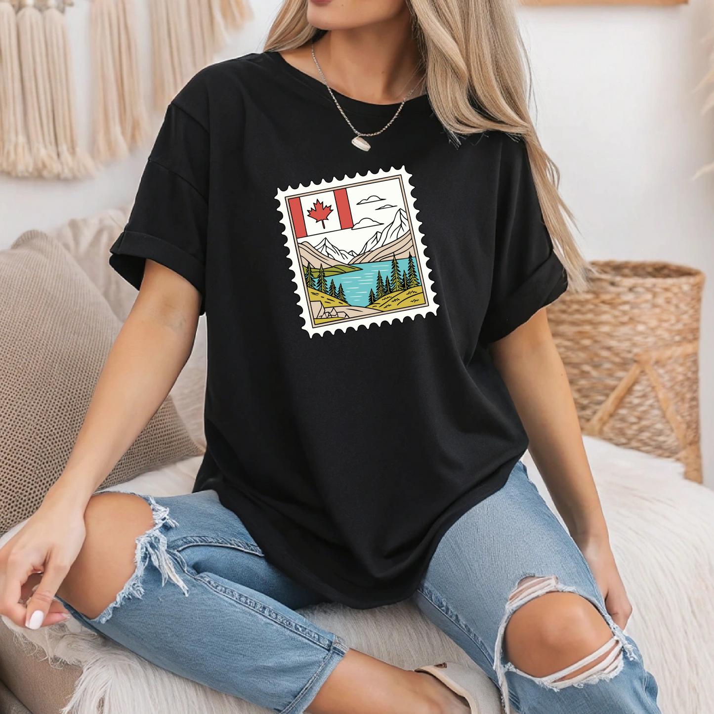 On the front of this custom Canadian pride short sleeve shirt is an image of a Canadian postage stamp with the Canadian flag in one corner and an image of mountains, a lake, and trees the make up the rest of the stamp.