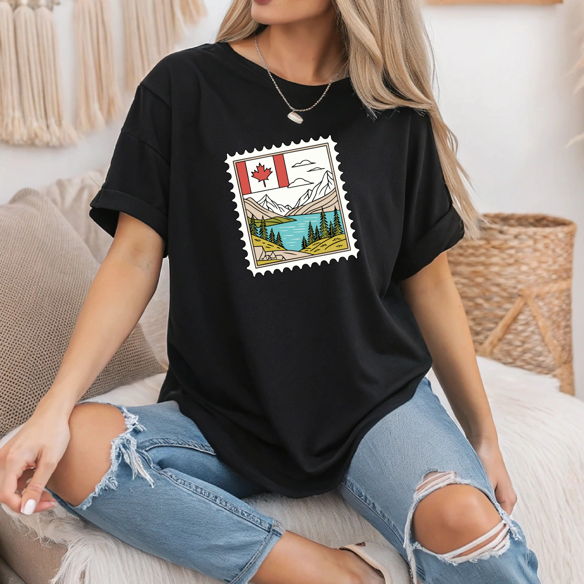 On the front of this custom Canadian pride short sleeve shirt is an image of a Canadian postage stamp with the Canadian flag in one corner and an image of mountains, a lake, and trees the make up the rest of the stamp.