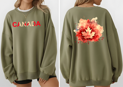 On the front of this Canadian pride pullover sweater is Canada in red and beige letters with a maple leaf in the middle, on the back of the sweater is a large maple leaf that looks like it has been spray painted onto the sweater in red and beige.
