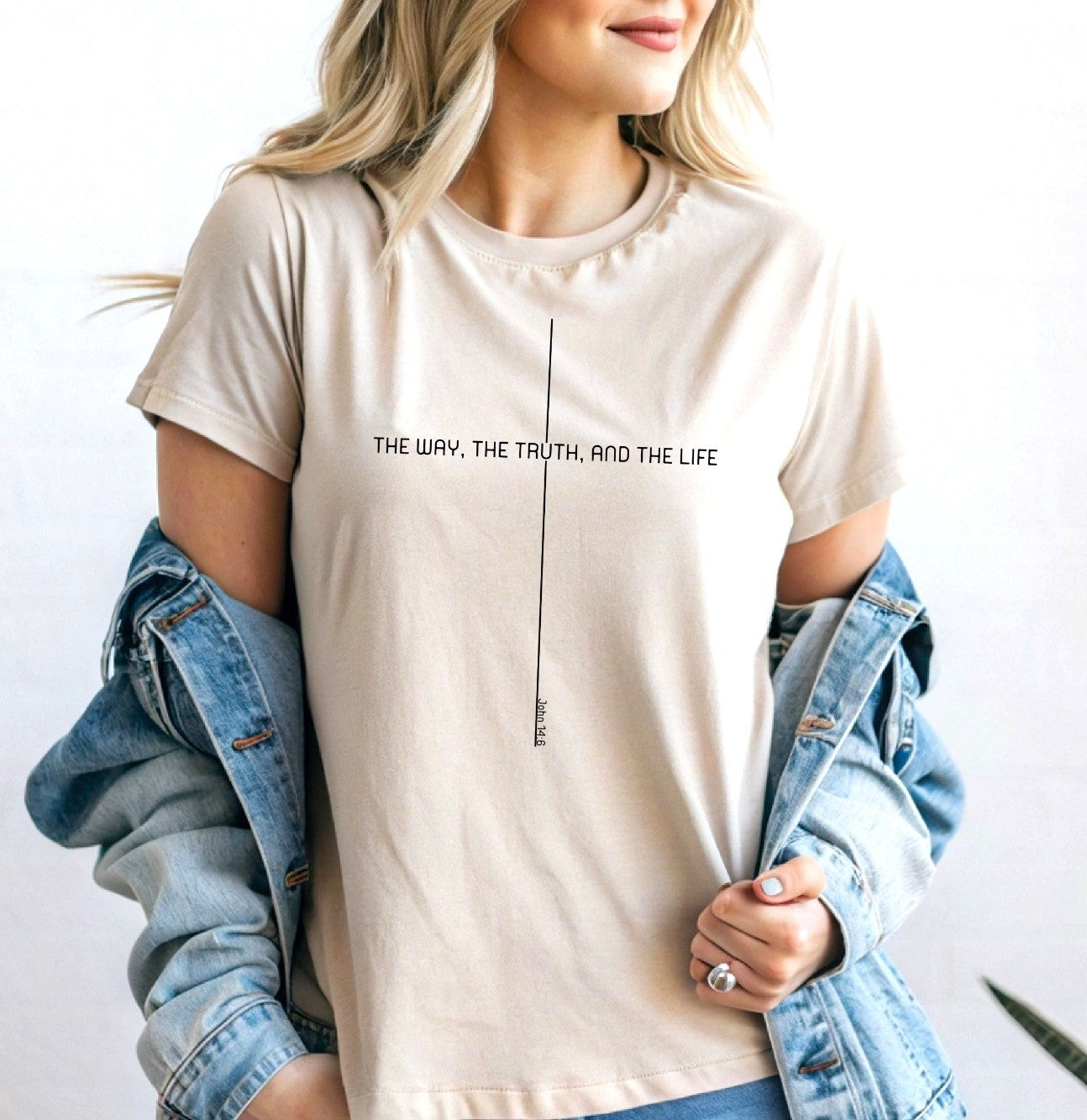 On the front of this custom faith inspired handmade t-shirt is a cross with the bible verse The Way, The Truth, and The Life John 14:6 in a modern font.
