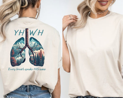 On the back of this handmade custom Christian short sleeve shirt is the word "YHWH" in large blue lettering with an image of a set of lungs with images of mountain scenery in each lung. The words "Every breath speaks His name" are underneath the image of the lungs.