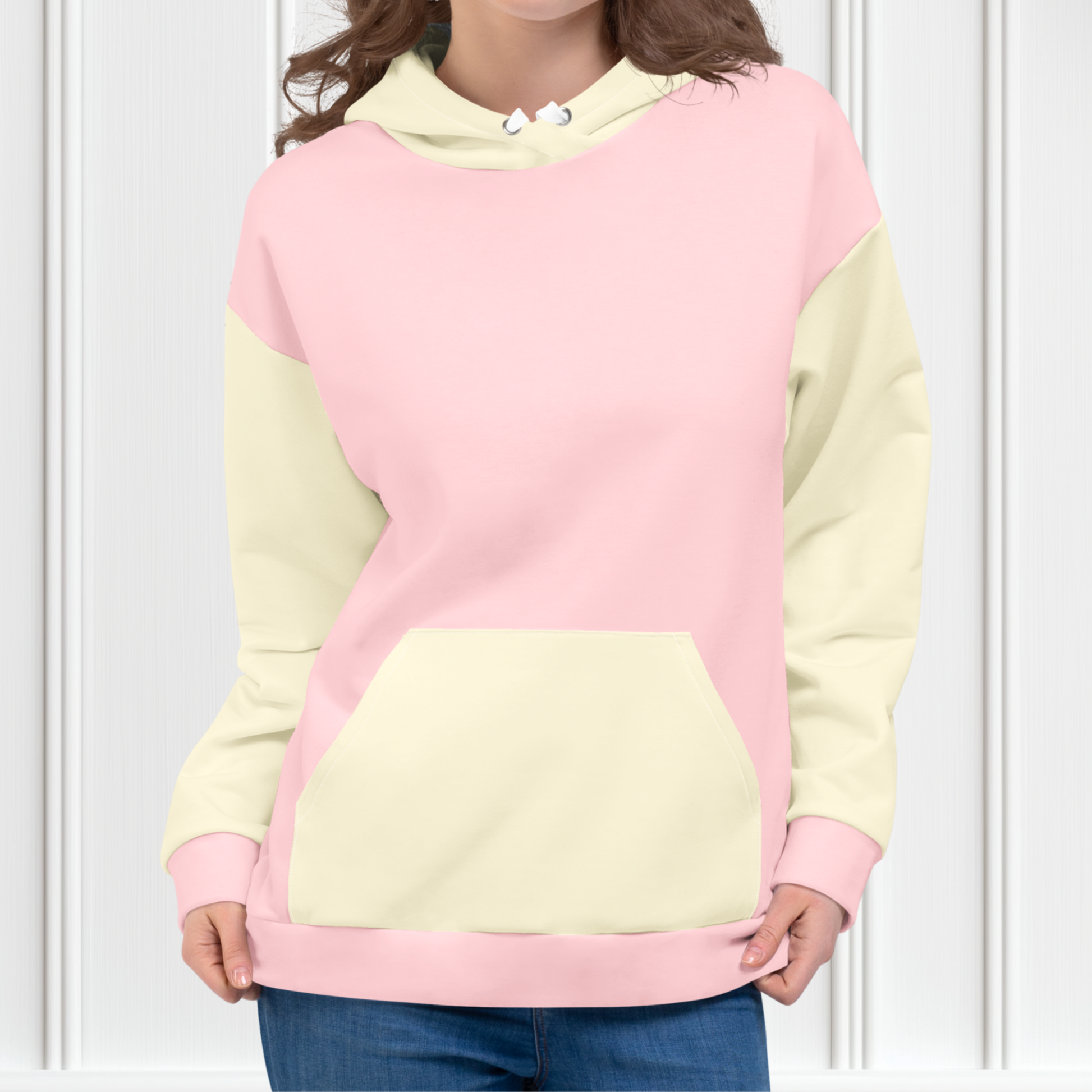 A custom women's color block hoodie with the front and the back of the hoodie being a light pastel pink, the front pocket, both sleeves and the hood are a light ivory in color.