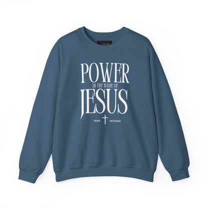 On the front of this Christian pullover sweatshirt it says Power In The Name Of Jesus with a Jesus cross underneath it, on either side of the cross are the words Fear and Nothing.