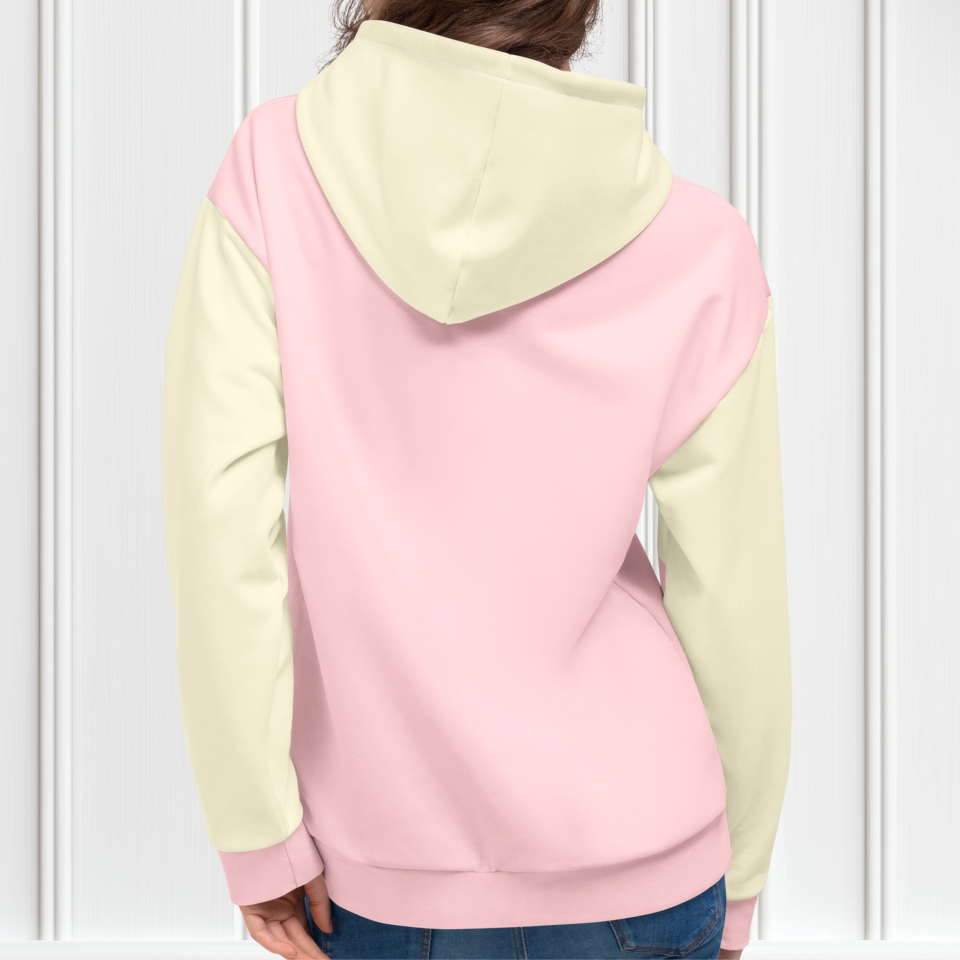 A custom women's color block hoodie with the front and the back of the hoodie being a light pastel pink, the front pocket, both sleeves and the hood are a light ivory in color.