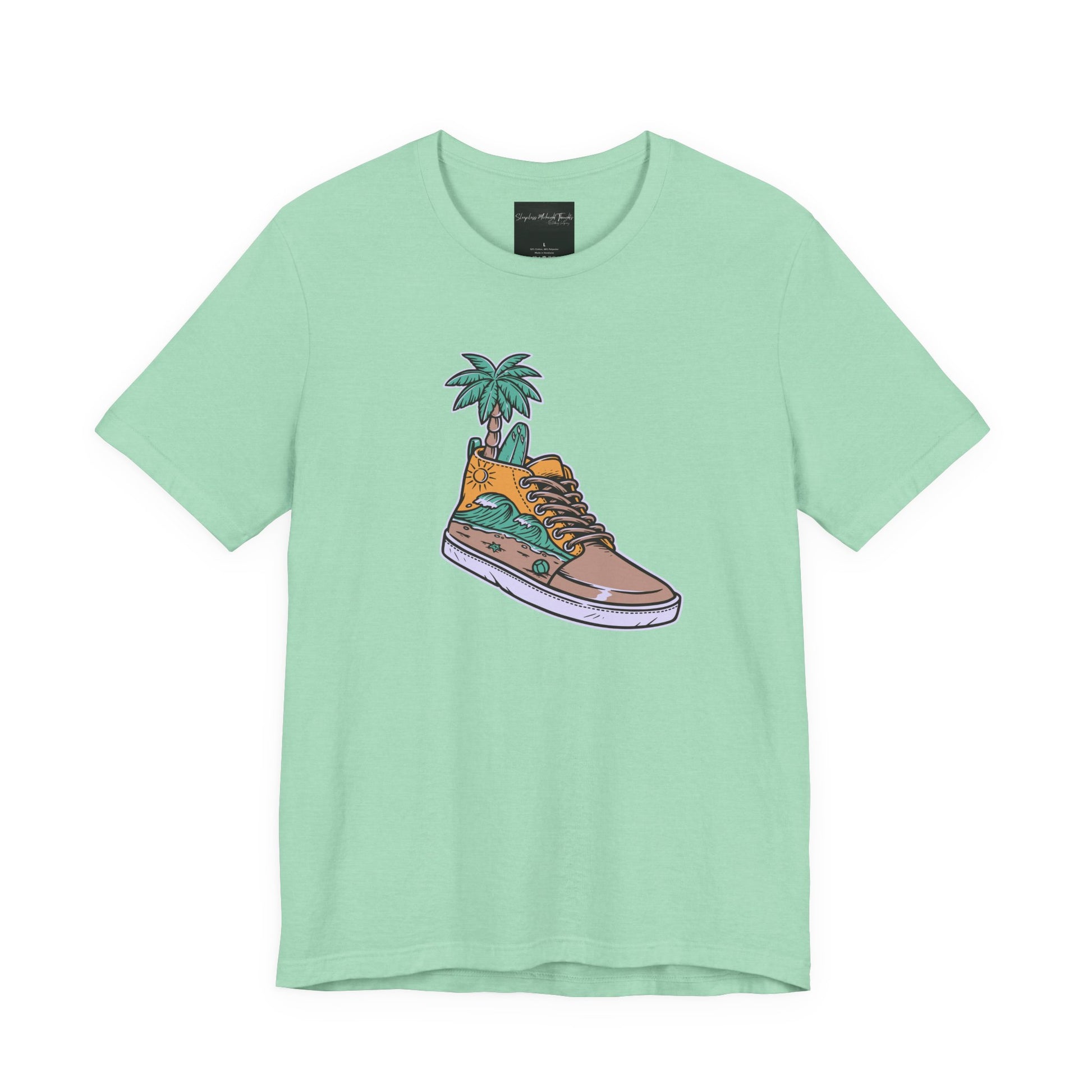 On the front of this custom handmade short sleeve shirt is an image of a high top running shoe with ocean waves running along the side of the shoe, coming out of the top of the shoe where your foot goes is a palm tree and a surf board.