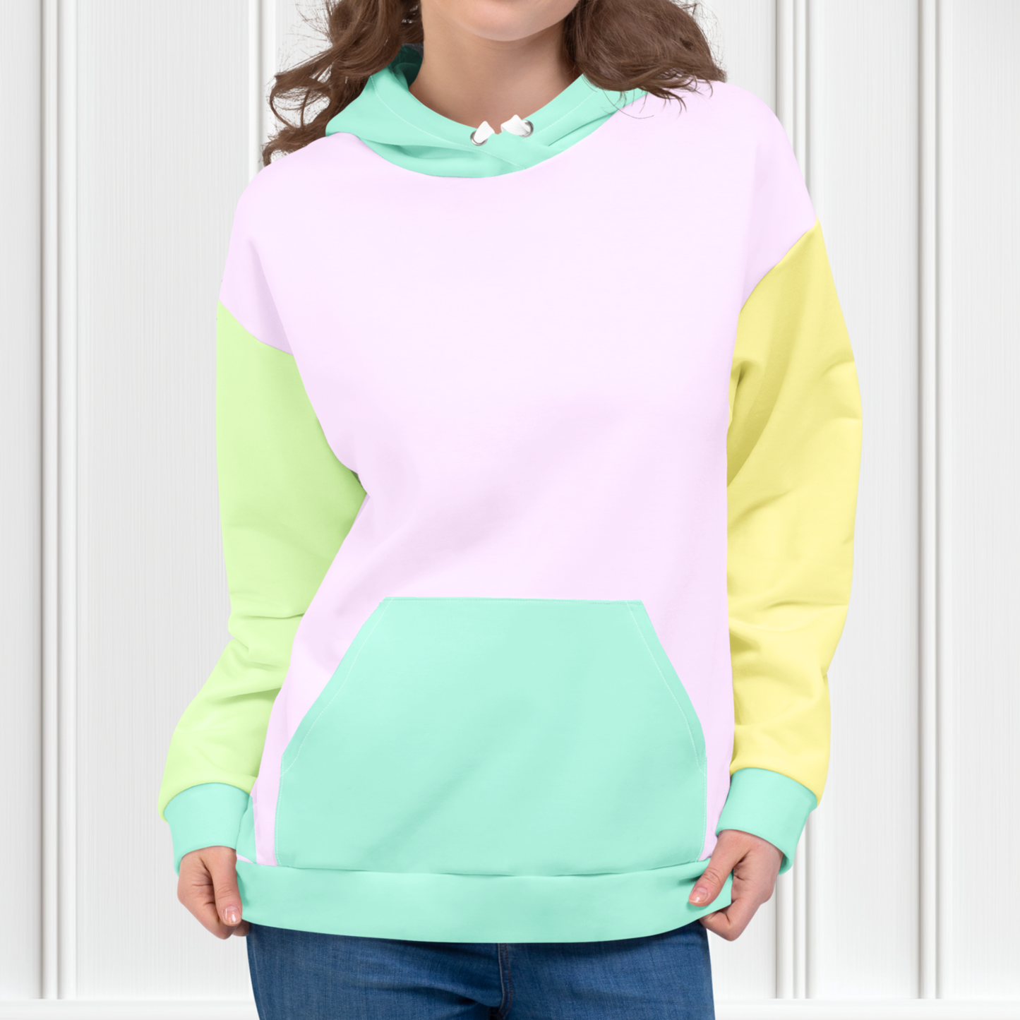 A custom hand sewn unisex hoodie that has a pastel color block design, the front and the back of the sweater are a light purple with the bottom waistband, the front pocket, hood and each cuff is a light mint green, the left sleeve is yellow and the right sleeve is a light grass green.