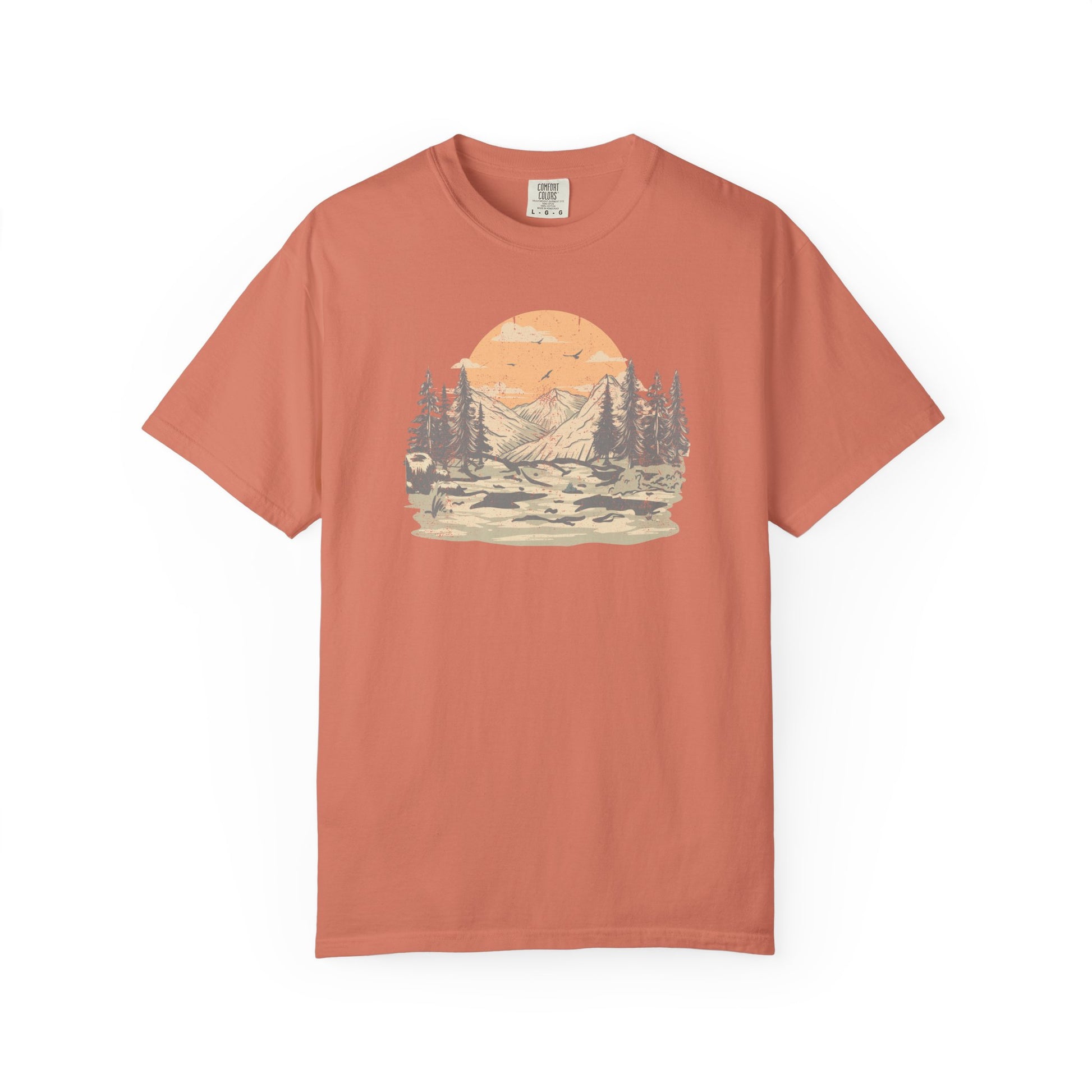 On the front of this custom comfort colors short sleeve t-shirt is a large vintage image of a large valley that opens up to a mountain range with pine trees , there is a large sun in the background with birds flying all around, this t-shirt is completely vintage.