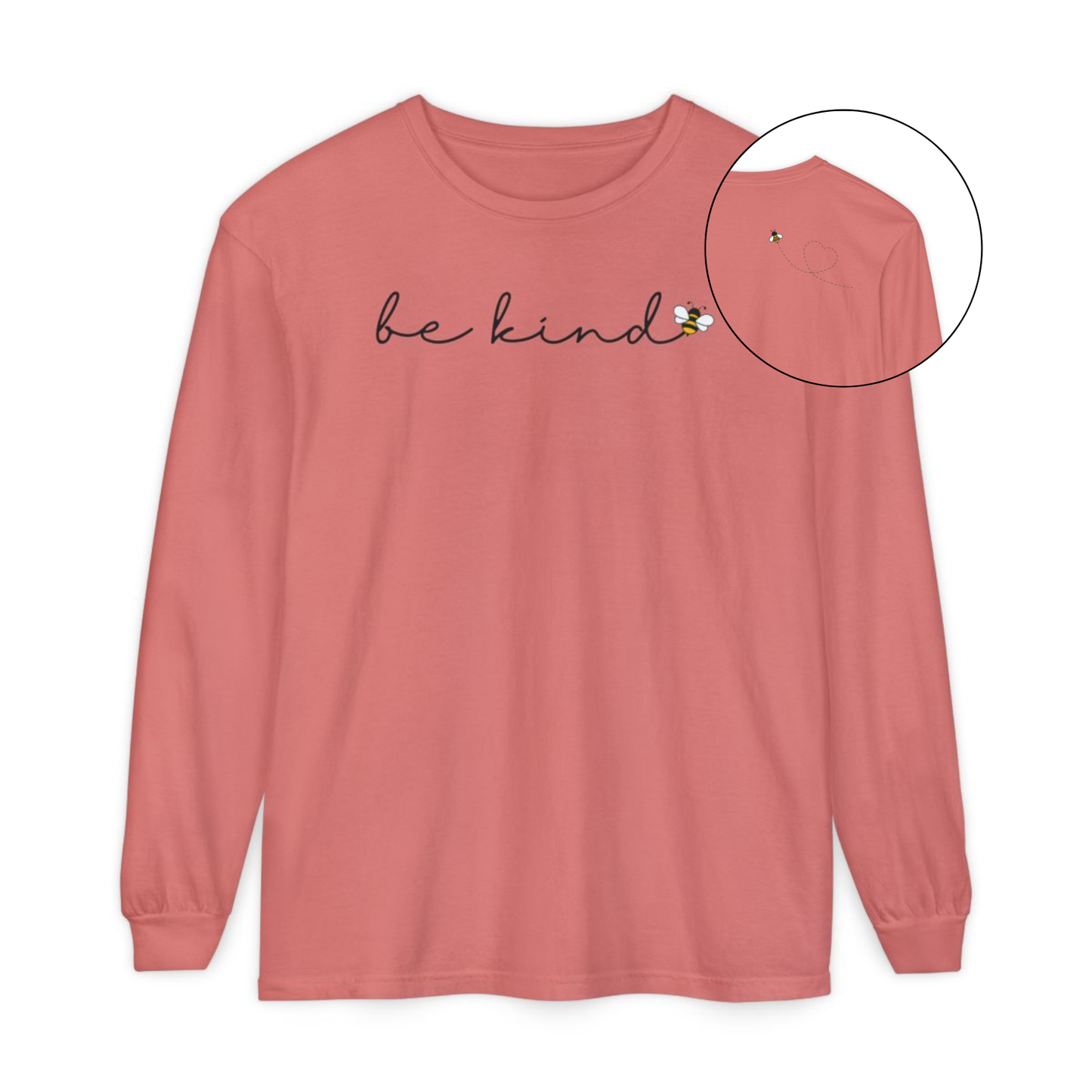 On the front of this custom unisex long sleeve shirt are the words be kind in a simple cursive font, with a bumble bee on the right side of the letter kind, on the back right shoulder there is an image of a bumble bee flying and leaving a trail behind it in the shape of a heart.