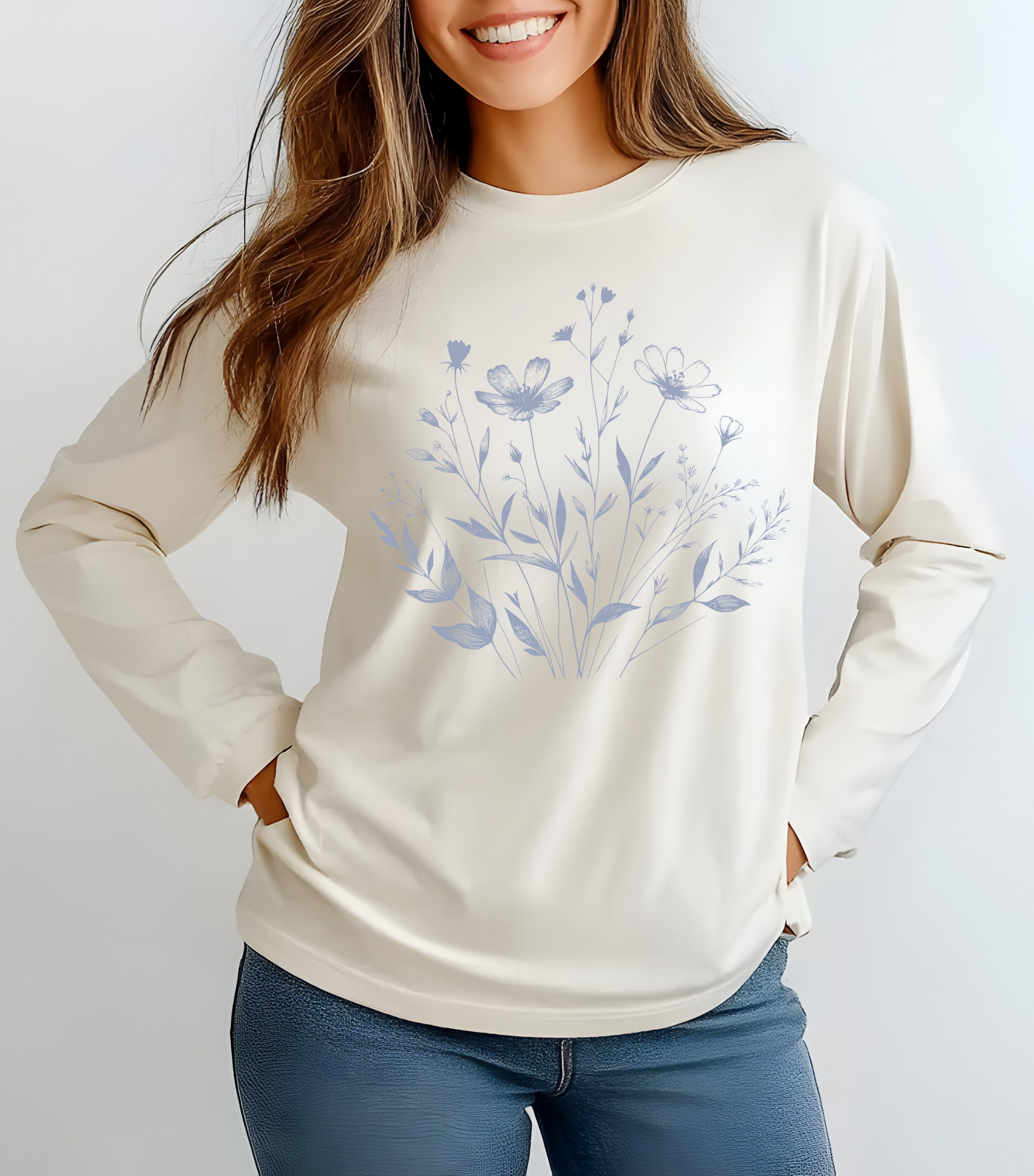 On the front of this custom women's long sleeve t-shirt is a image of a bunch of wildflowers and leaves coming from the bottom of the shirt to the very top, the flowers and leaves are in a light blue color.