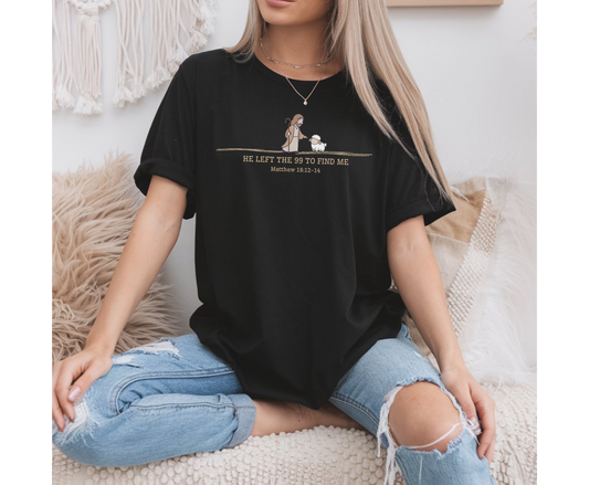 On the front of this custom Christian t-shirt is an image of Jesus the shepherd standing next to a little lamb, underneath the image are the words He left the 99 to Rescue Me Matthew 18:12-14.