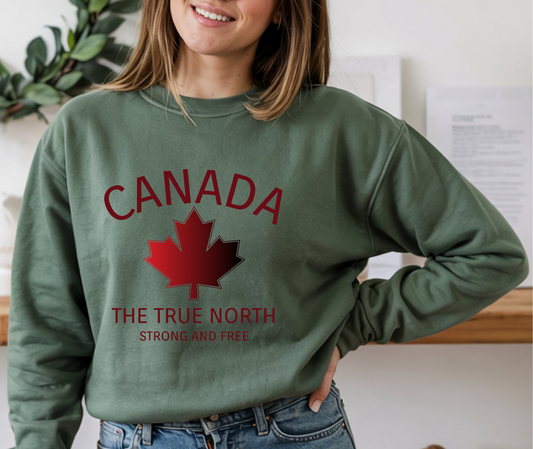 On the front of this custom Canadian pullover sweatshirt is the word Canada in large letters in a half circle overtop of a red and black maple leaf, the words The true north strong and free are underneath the maple leaf, they are also in red.