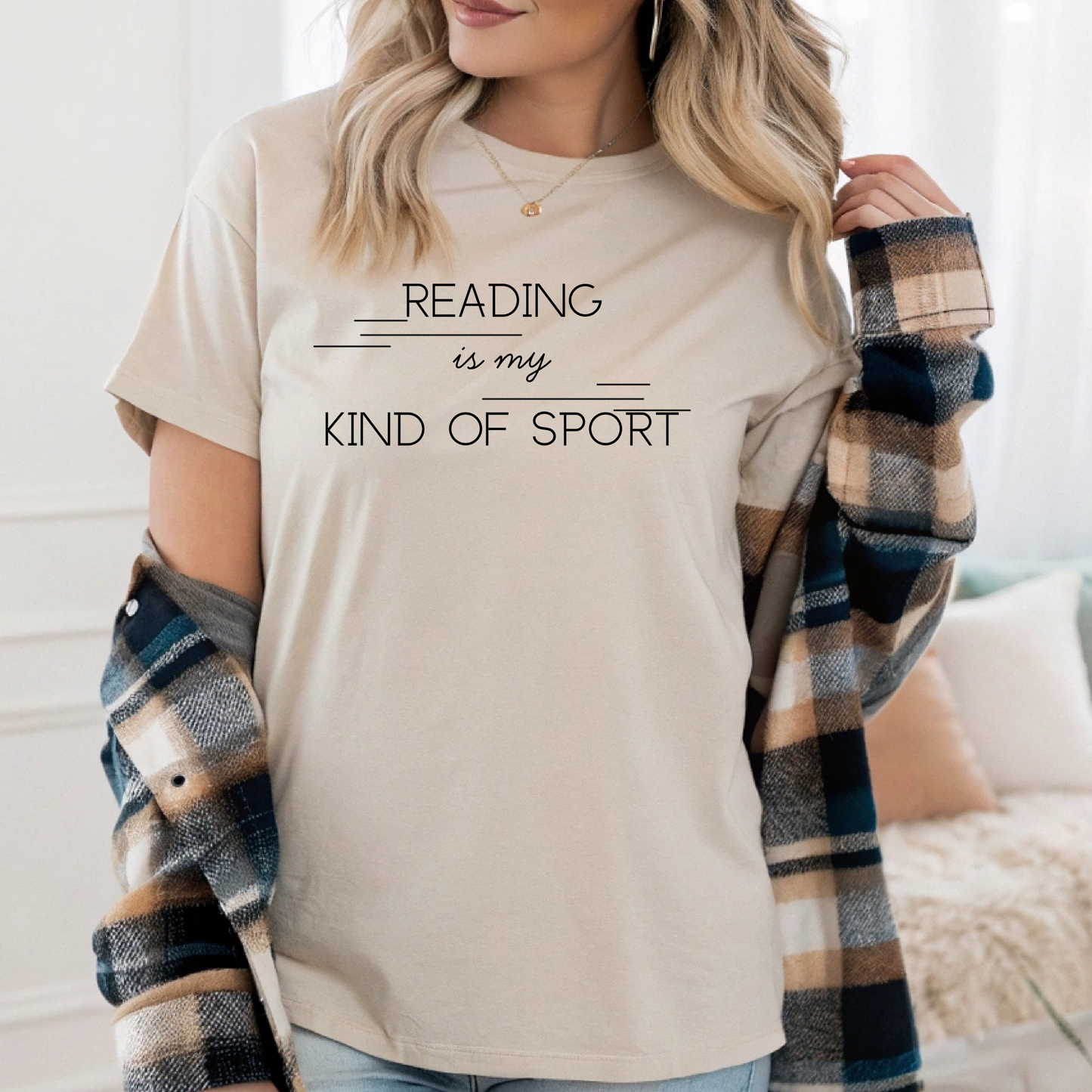 On the front of this custom booklover short sleeve shirt are the words Reading is my Kind of Sport, in a modern font with different length lines on either end of the writing giving the shirt a retro look.