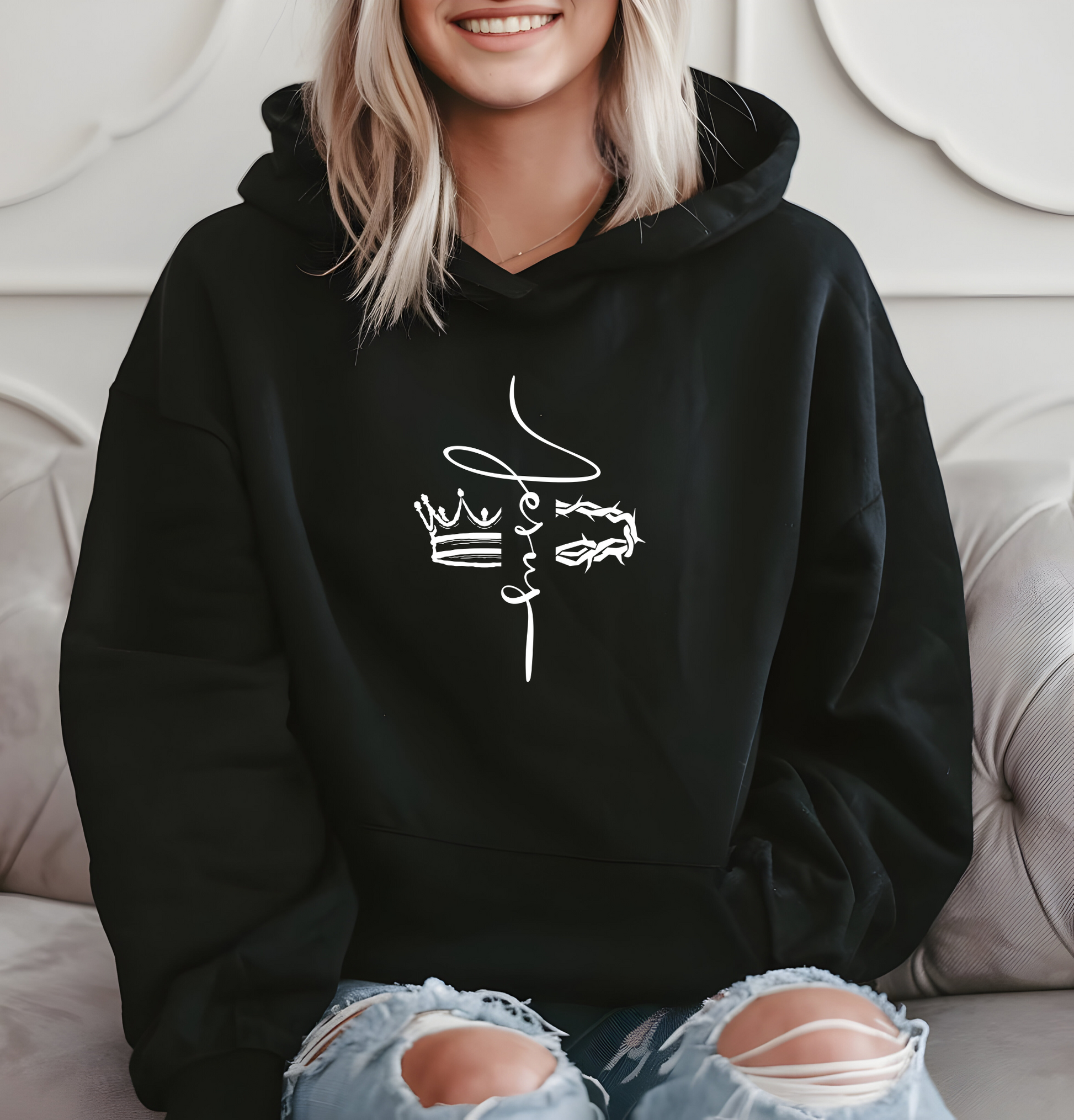 This custom unisex Christian hoodie features the name of Jesus in a cursive font down the center of the front of the sweater, there is an image of a crown on the right and a crown of thorns on the left of the name of Jesus.