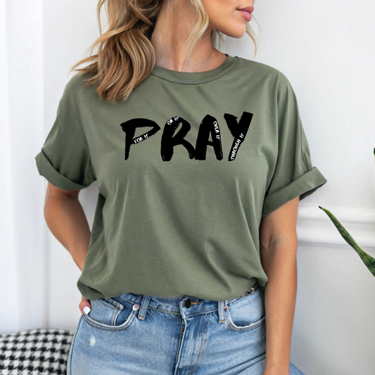 On the front of this custom handmade short sleeve shirt is the word pray in large black lettering, inside each letter in smaller writing are the words For it On it Over it and Through it in a different color font.