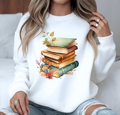 On the front of this custom book lovers sweatshirt is a stack of vintage books with a bunch of wildflowers all around the books.
