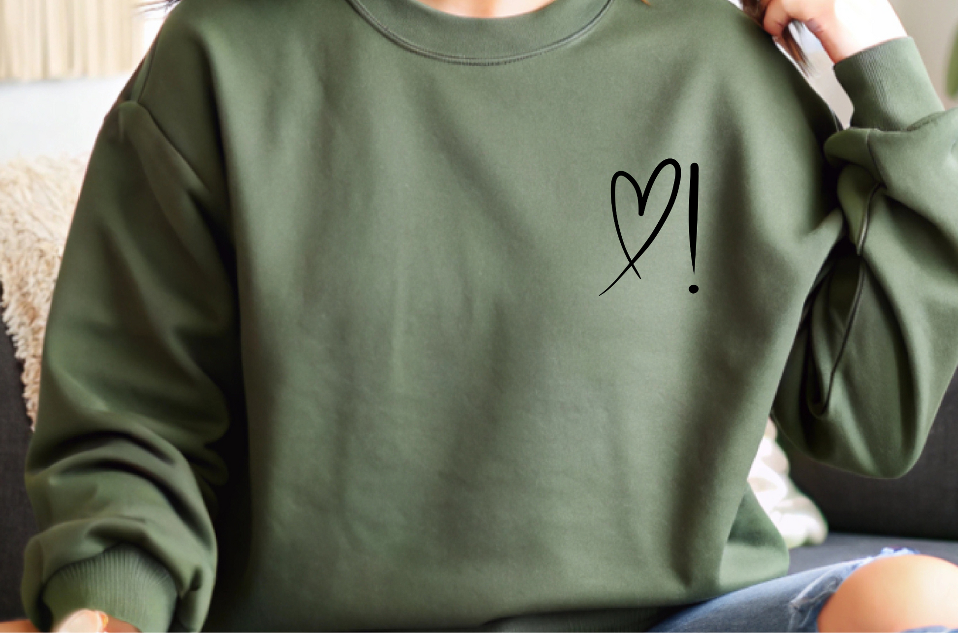 A handmade unisex oversized pullover sweatshirt with a crewneck, on the front left chest of the sweater in white is a heart with an exclamation point on the left hand side if the heart
