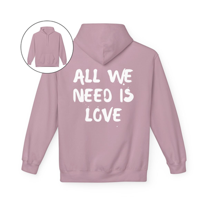 On the back of this custom unisex hoodie are the words all we need is love, the words look like they have been spray painted onto the sweater.