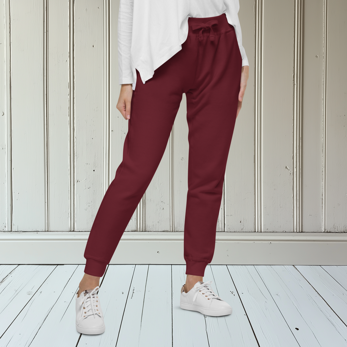 A pair of super soft custom unisex fleece sweatpants with a male lion head on the back calf of the right leg embroidered in silver.