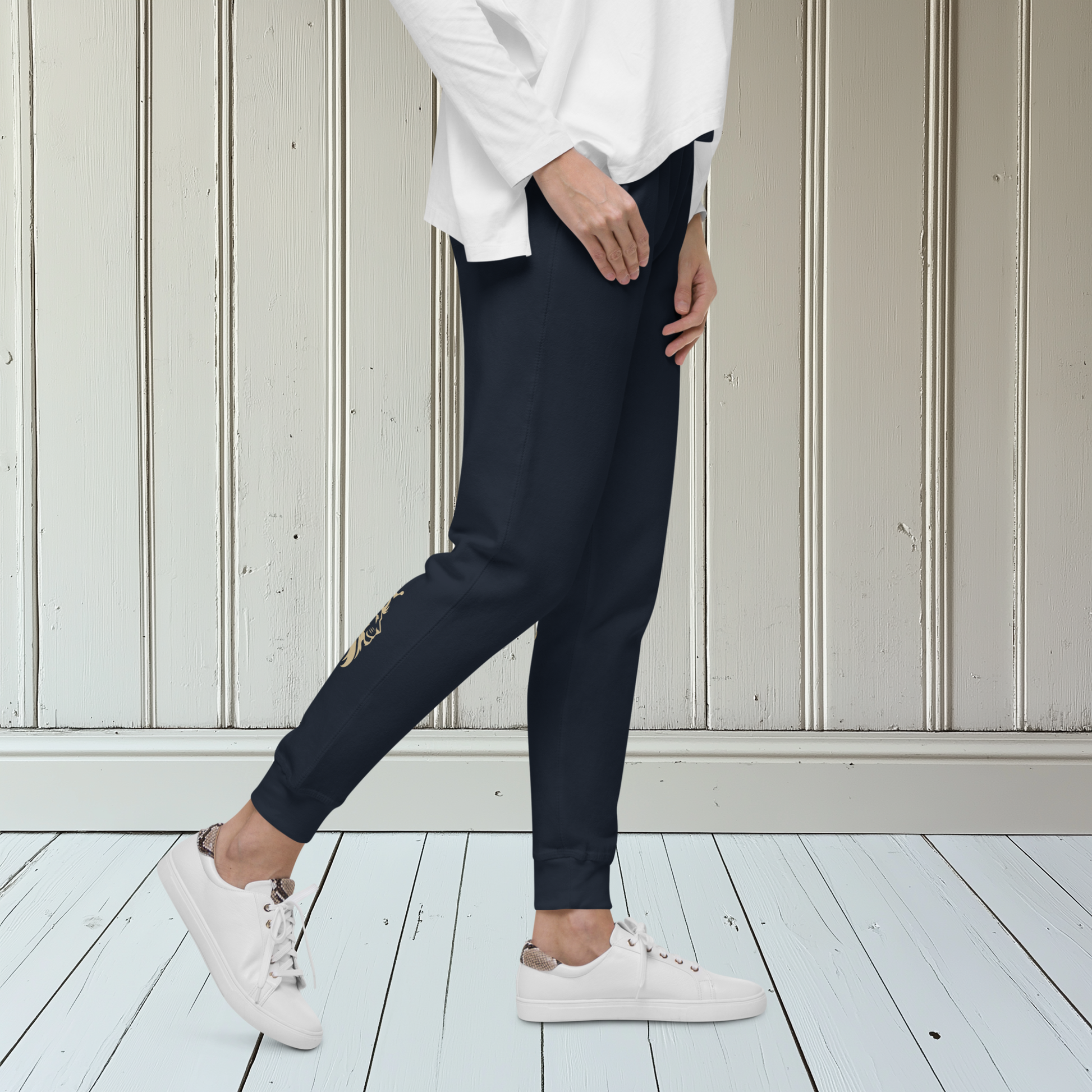 A pair of super soft ankle length unisex sweatpants, there are two pockets on the front and one pocket on the back right, the word warrior is in gold on the back left leg from the knee down and a male lion with a crown on the other