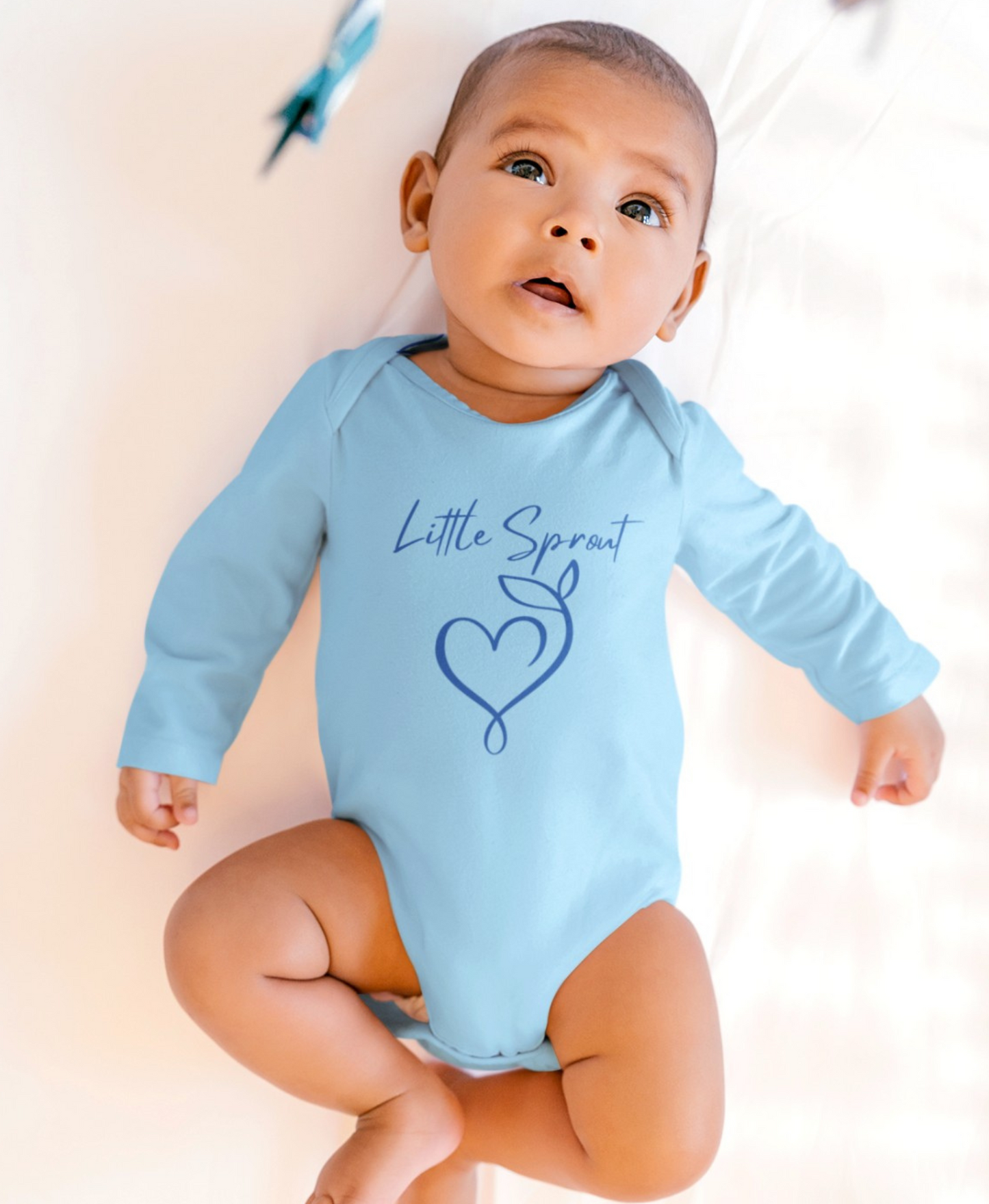 This adorable super soft infant onesie features the words 'little sprout' with a heart and two leaf stem design on the front, creating a cute and playful vibe.
