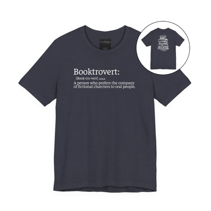On the front of this custom unisex short sleeve shirt is the word booktrovert with the definition of the word underneath, on the back of the shirt is an image of a large stack of books.