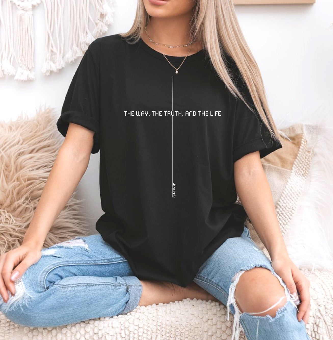 On the front of this custom faith inspired handmade t-shirt is a cross with the bible verse The Way, The Truth, and The Life John 14:6 in a modern font.