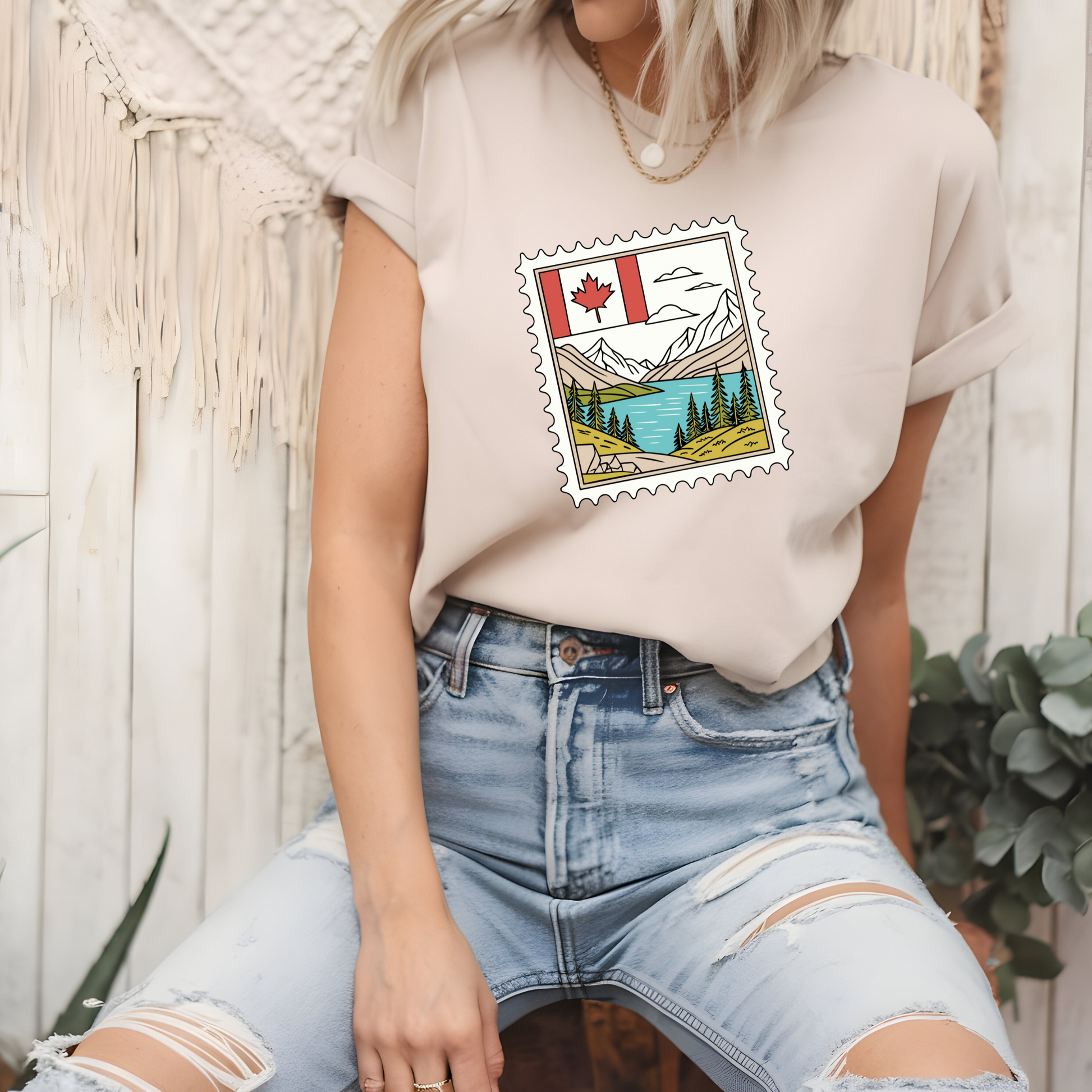On the front of this custom Canadian pride short sleeve shirt is an image of a Canadian postage stamp with the Canadian flag in one corner and an image of mountains, a lake, and trees the make up the rest of the stamp.