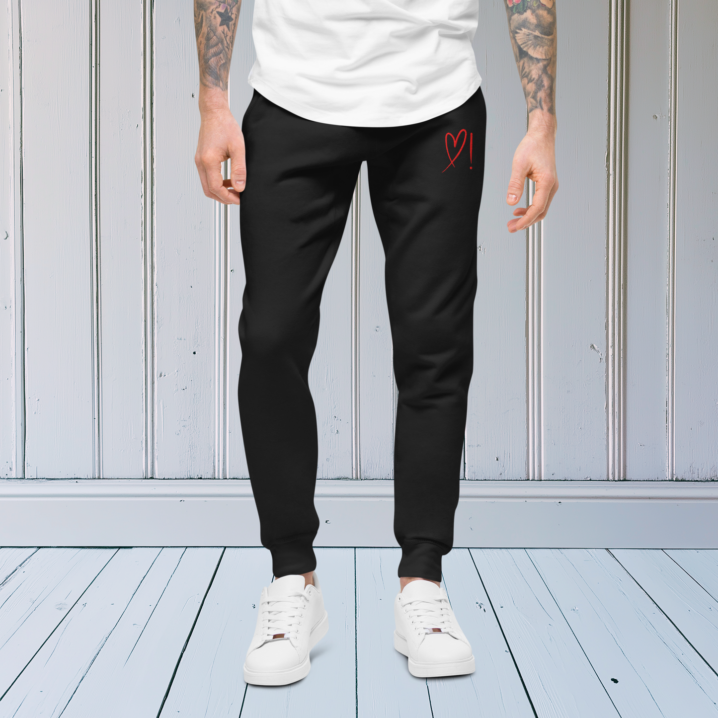 A pair of super soft ankle length unisex sweatpants, there are two pockets on the front and one pocket on the back right. There is a red heart with an exclamation point next to it embroidered on the front left pocket.