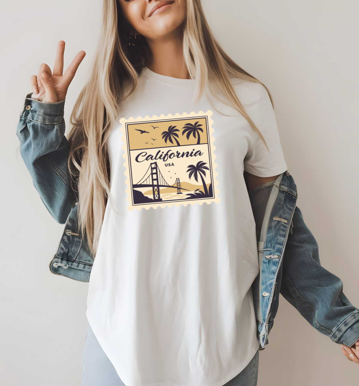 On the front of this custom vintage short sleeve shirt is a California postage stamp with images of the golden gate bridge, palm trees and the ocean on it, the entire stamp is different shades of beige.