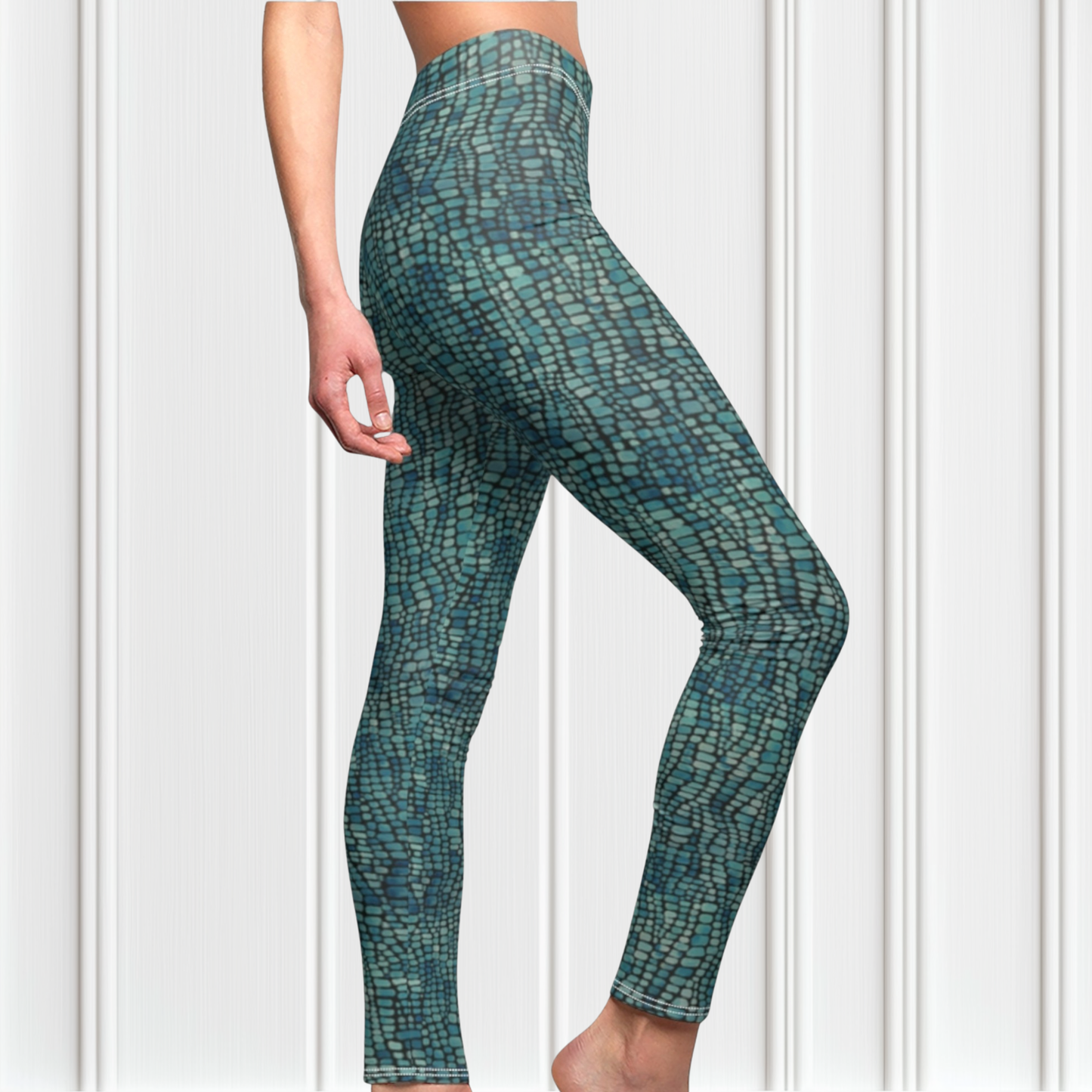 A pair of custom handmade high waisted women's leggings that have a emerald green and turquoise colored snake scale pattern all over the pants.