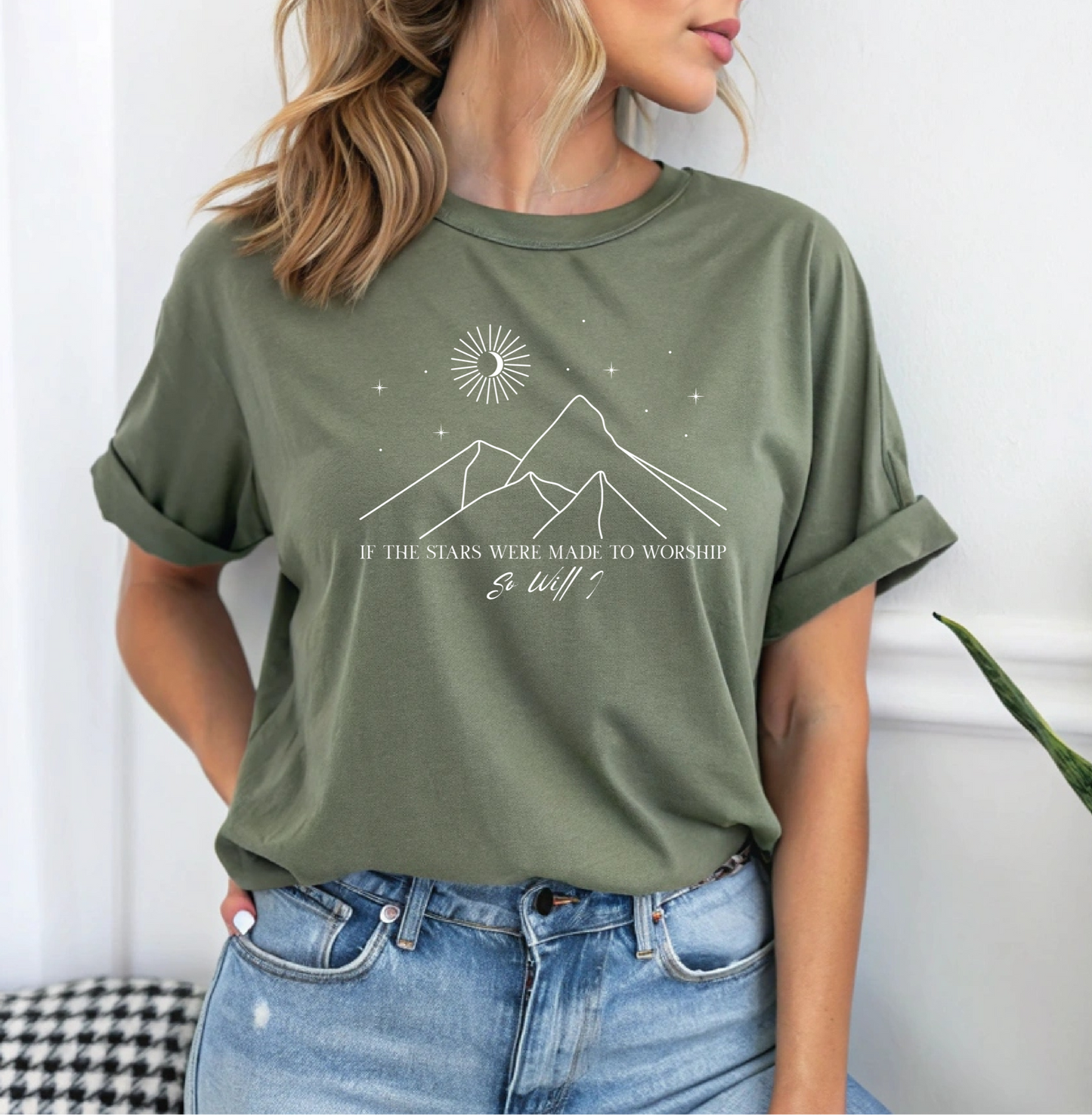 On the front of this custom Christian short sleeve shirt is a line drawing of mountains, and a moon and stars above the mountains, underneath the image are the words If the stars were made to worship so will I.