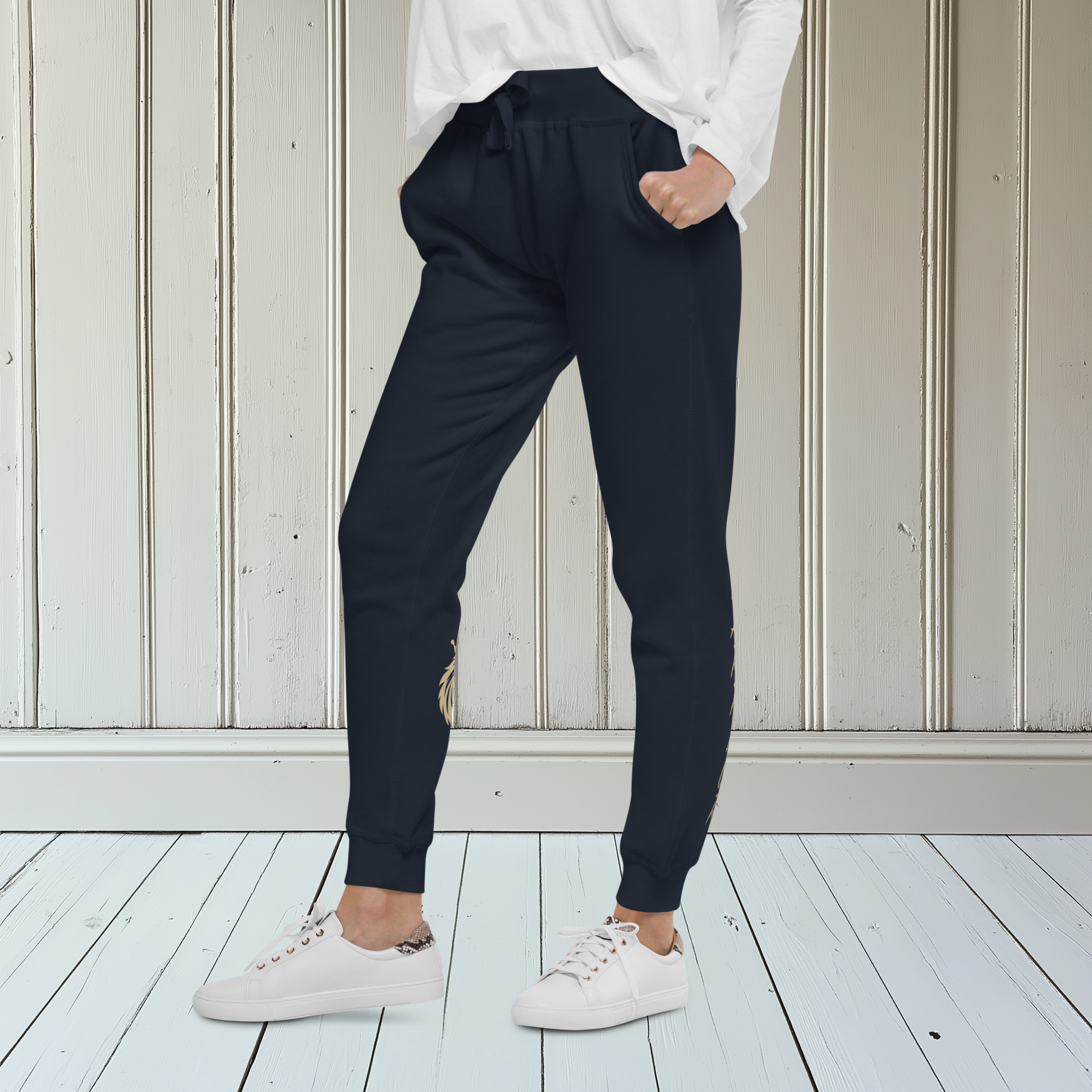 A pair of super soft ankle length unisex sweatpants, there are two pockets on the front and one pocket on the back right, the word warrior is in gold on the back left leg from the knee down and a male lion with a crown on the other