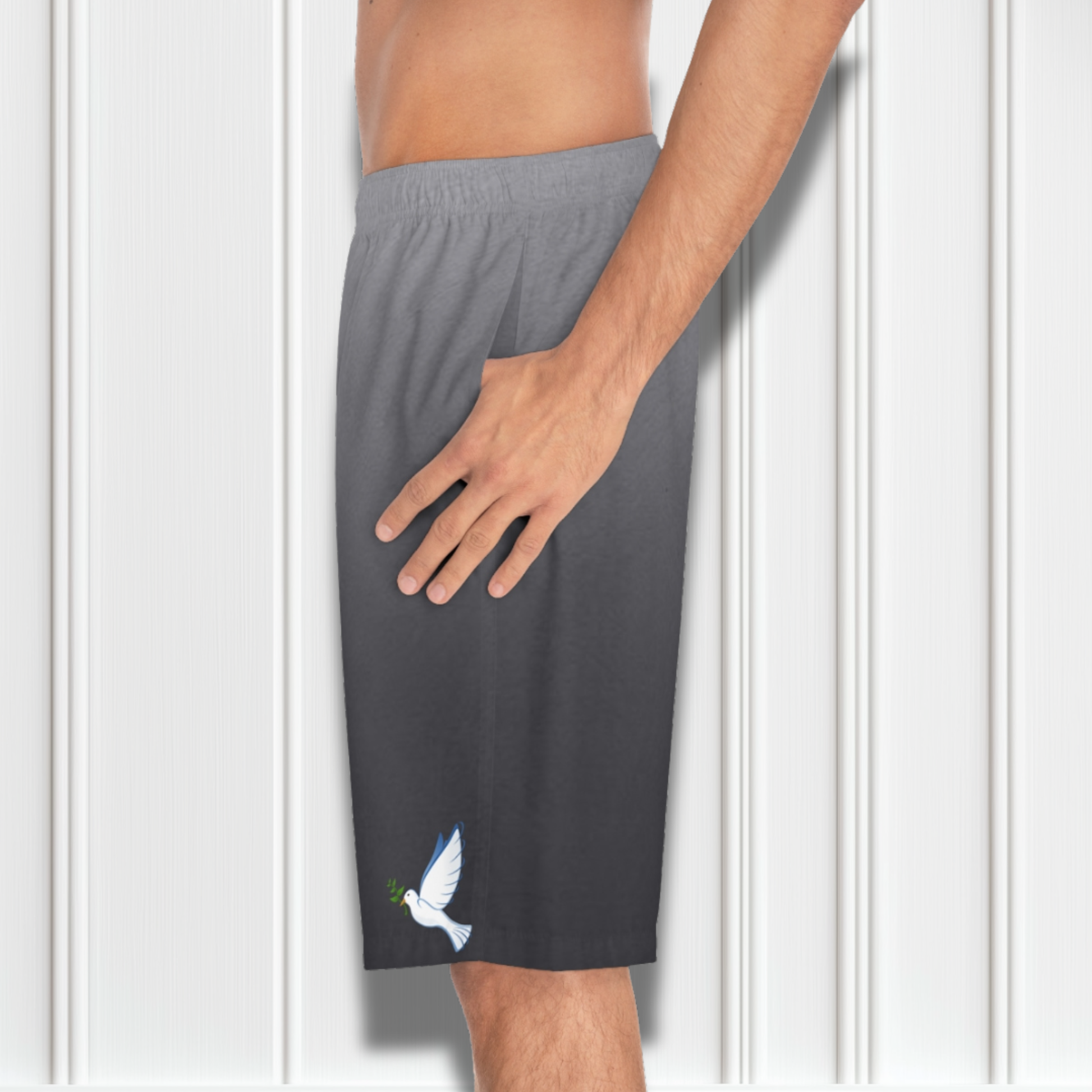 These custom men's board shorts feature a unique design with a ombre pattern starting with a light grey at the top then fading to a dark grey at the bottom, there is a symbol of a dove carrying a fig leaf on the front left side of the shorts just at the knee.