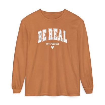 On the front of this custom unisex long sleeve shirt are the words Be Real in large bubble font with the words not perfect underneath the bubble letters, on the bottom there is a heart.