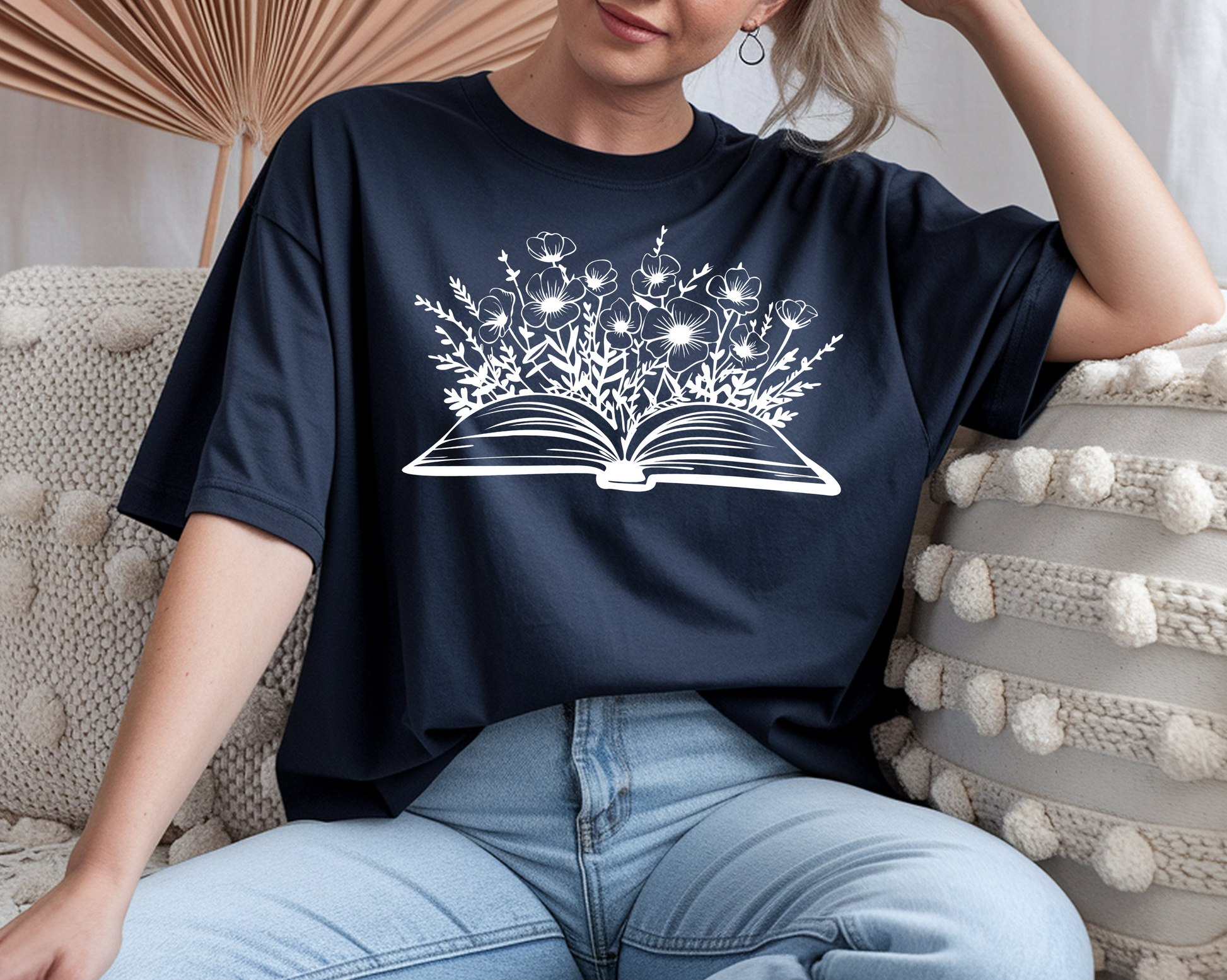 On the front of this custom women's book lover shirt is a image of a book with it opened in the middle, there are a bunch of wildflowers coming out of the center of the book.