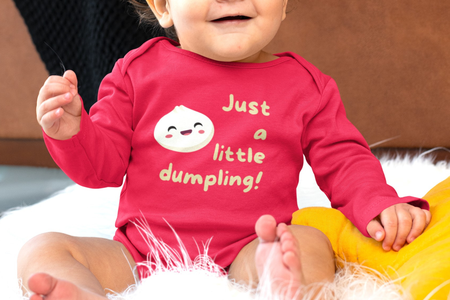 On the front of this custom infant onesie are the words Just A Little Dumpling with a image of a bao dumpling with a happy face next to the wording.