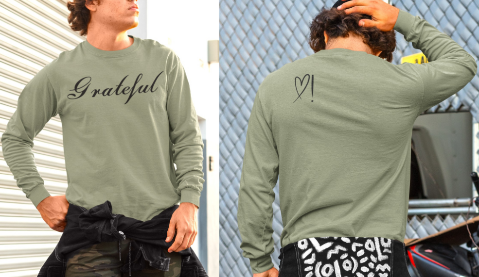 On the front of this custom long sleeve t-shirt in cursive writing is the word grateful on the upper chest, on the back left shoulder blade is an image of a heart with an exclamation mark next to it.